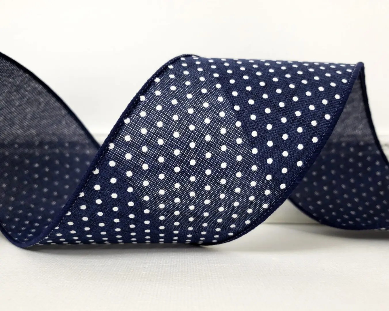 Little white dots on navy blue 4" wide wired ribbon from the Etsy shop of Cottage Crafts Online.