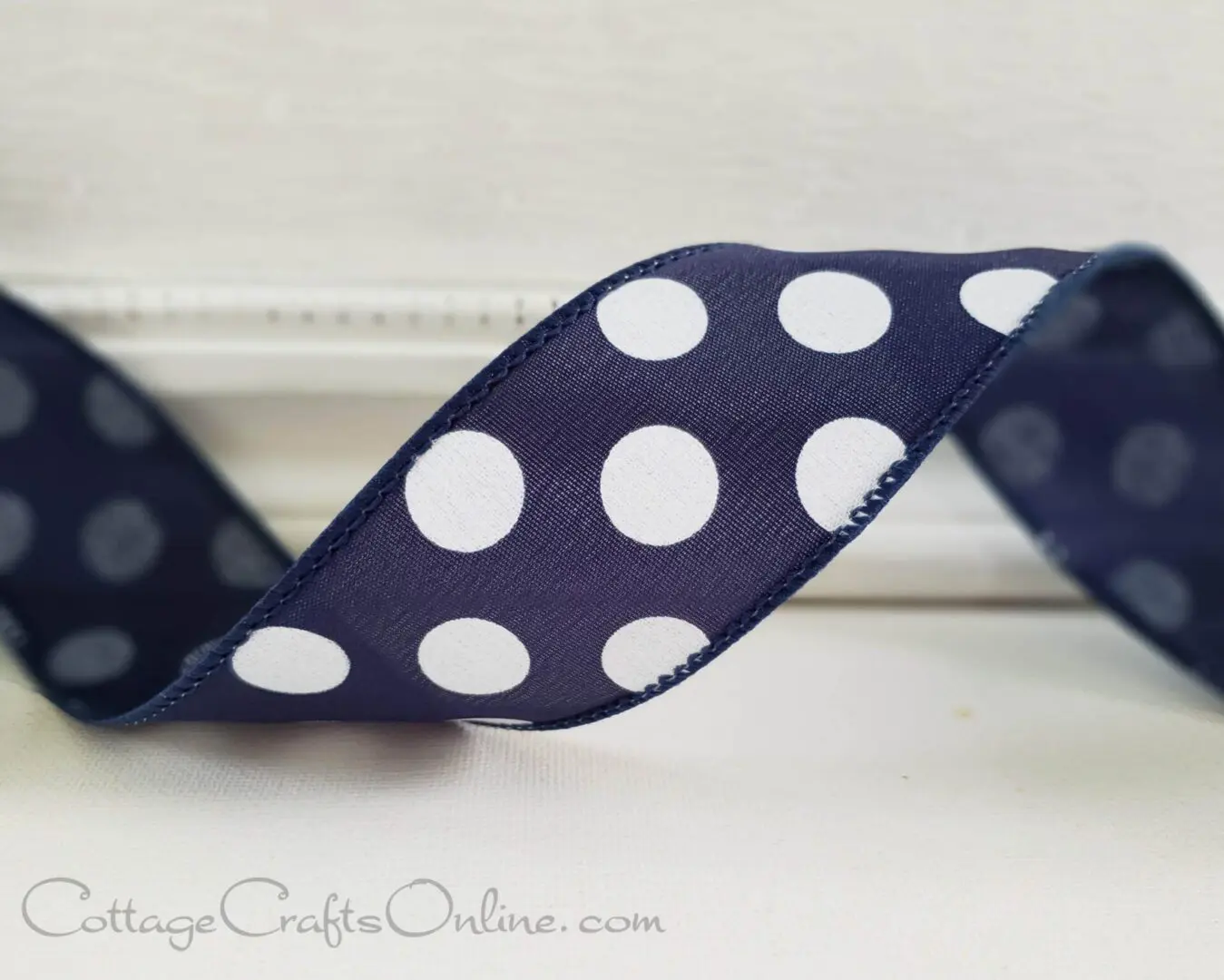 Big white dots on navy blue 1.5" wide wired ribbon from the Etsy shop of Cottage Crafts Online.