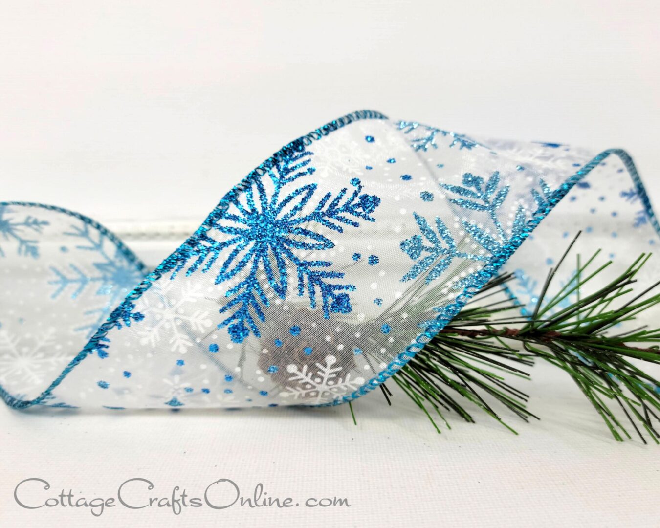 Blue glitter snowflakes on white sheer 2.5" wide wired ribbon from the Etsy shop of Cottage Crafts Online.