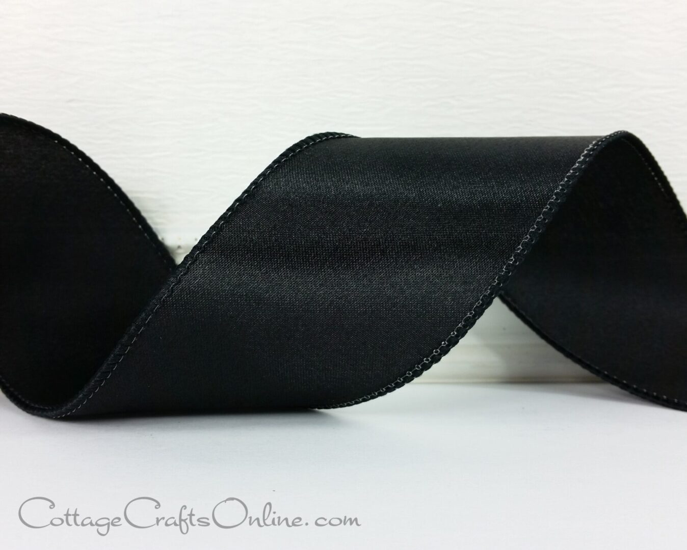 black satin ribbon on a white surface.