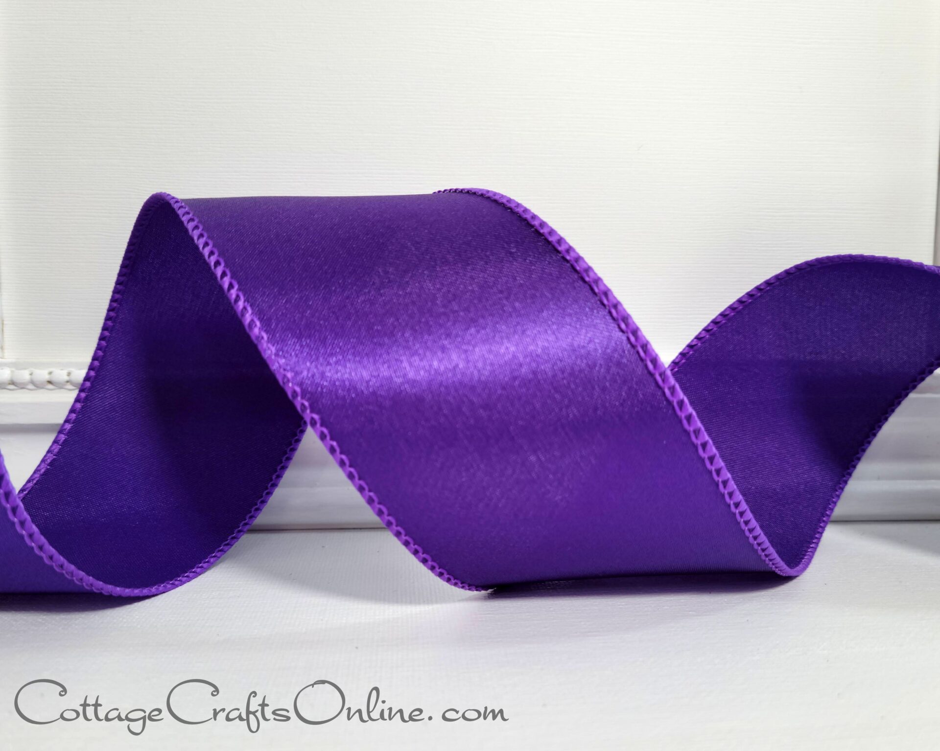 purple satin ribbon on a white table.