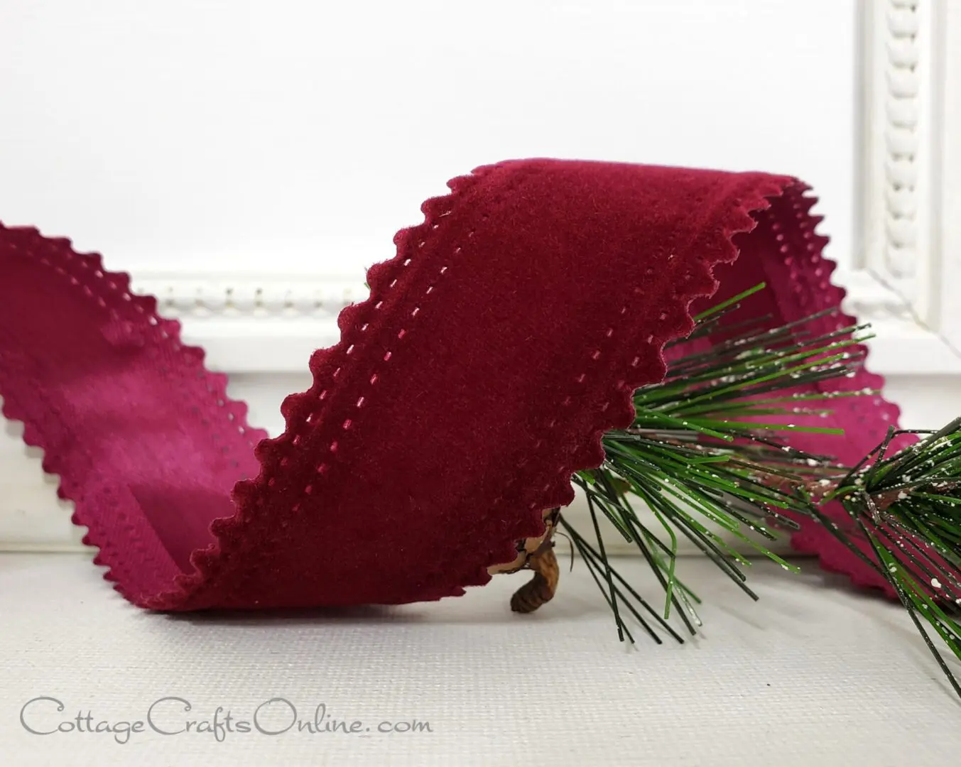 A new holiday ribbon featuring a burgundy velvet texture and a pine branch design.