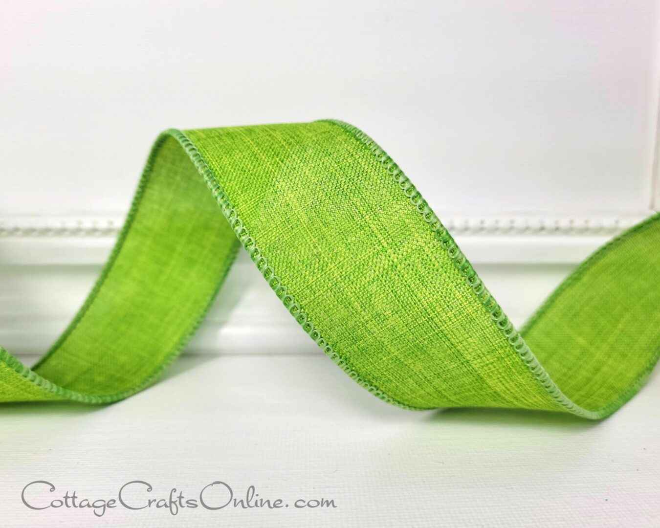 a lime green ribbon on a white wall at cottage crafts online.