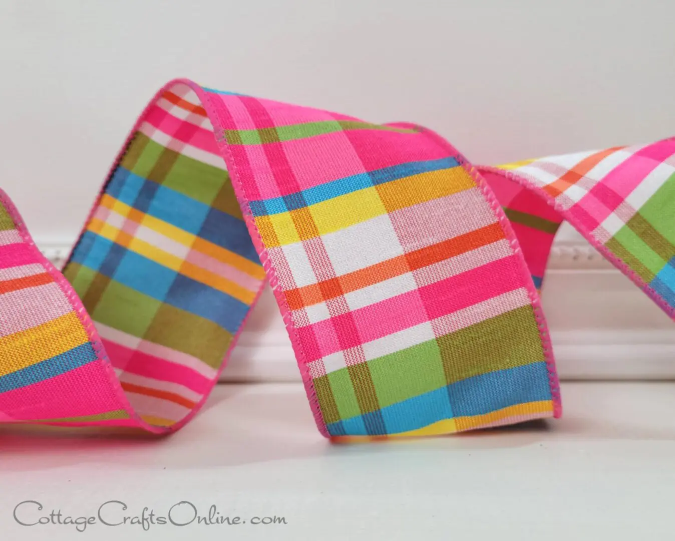 a brightly colored plaid ribbon on a white surface.