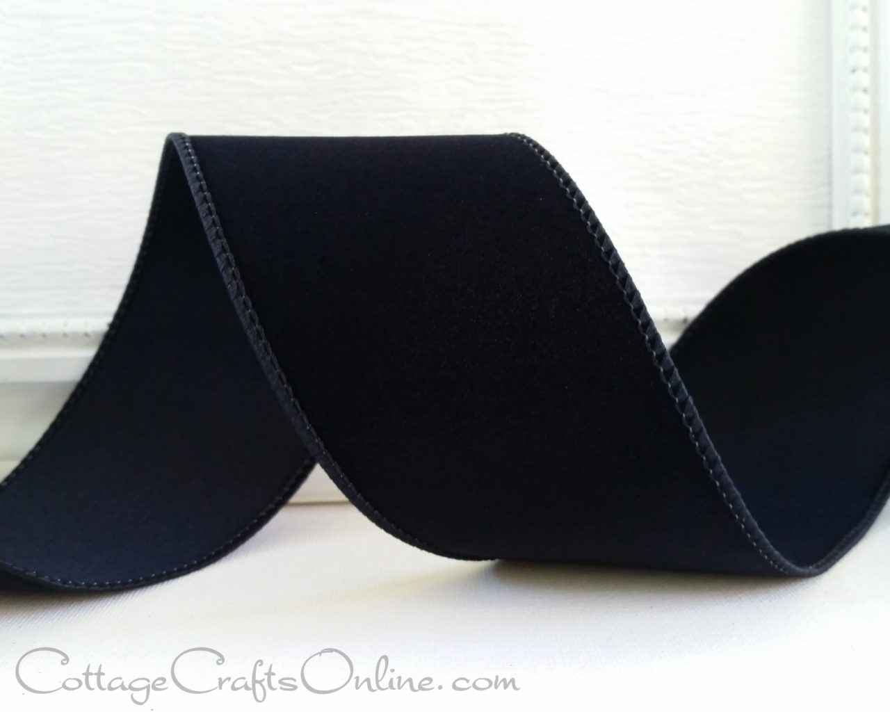 black grosgrain ribbon on a white table.