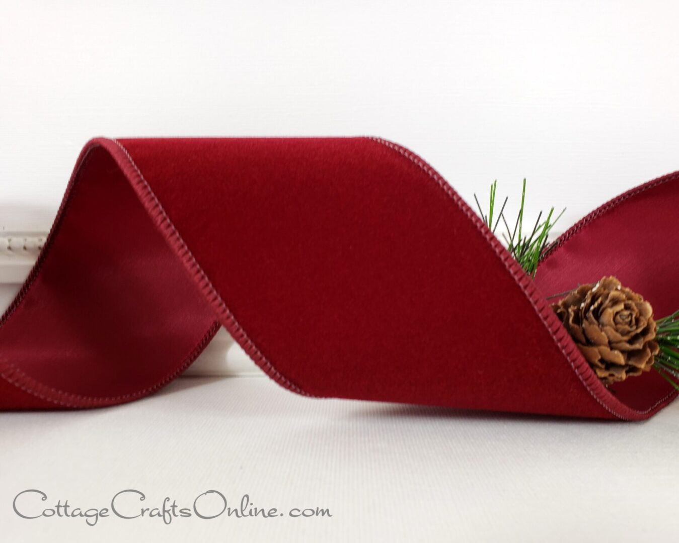 A red ribbon with pine cones on it