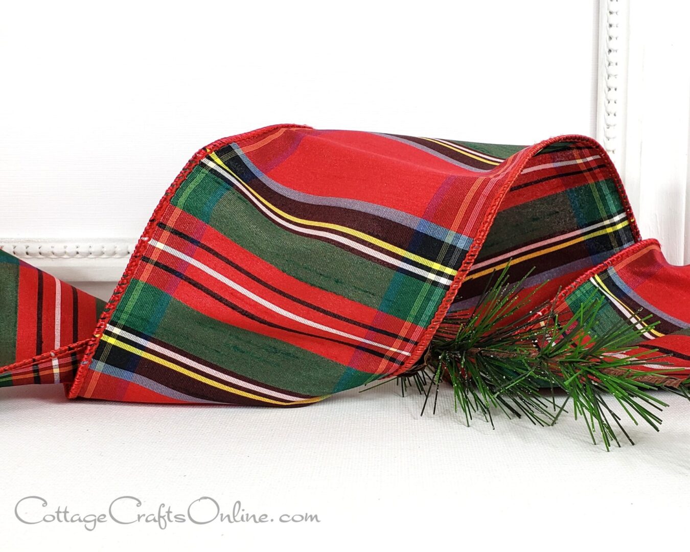 A red and green plaid ribbon laying on top of a table.