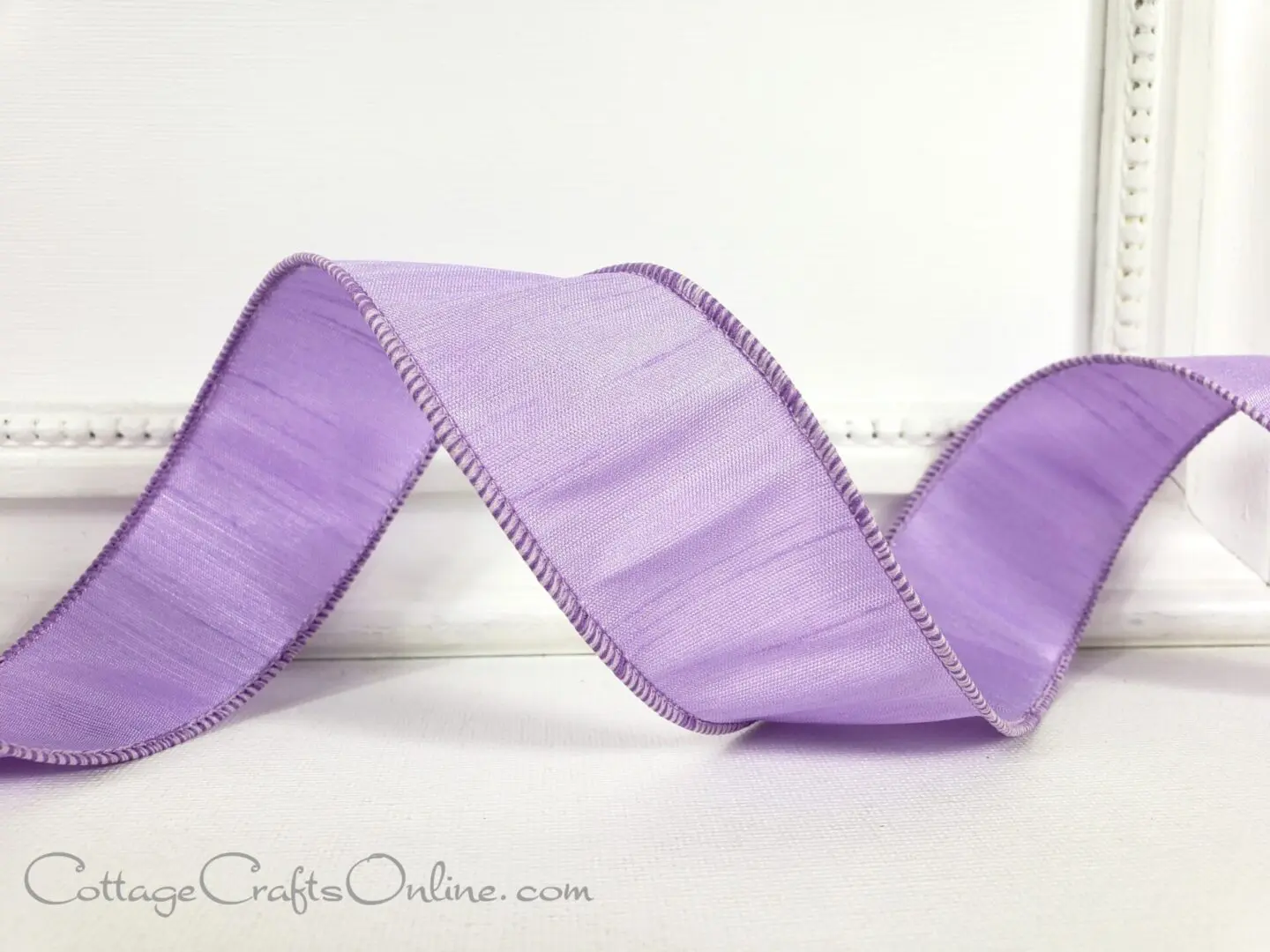 a purple satin ribbon on a white frame.