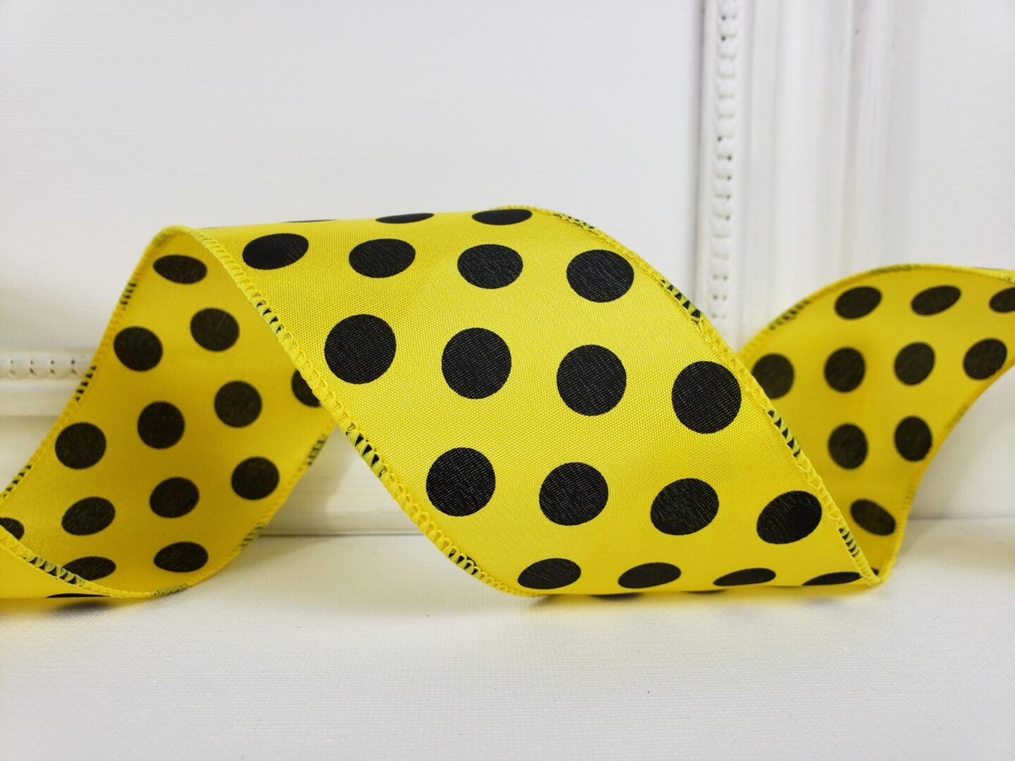 Large black dots on yellow satin 2.5" wide wired ribbon from the Etsy shop of Cottage Crafts Online.