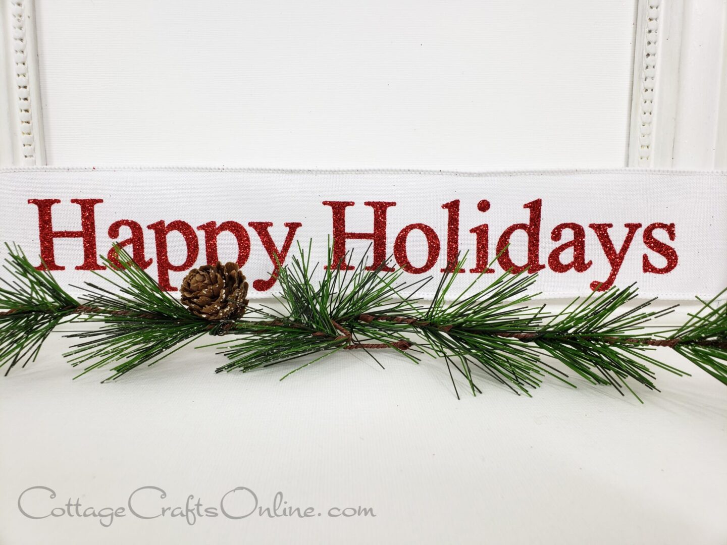 a happy holidays sign with pine branches on it.