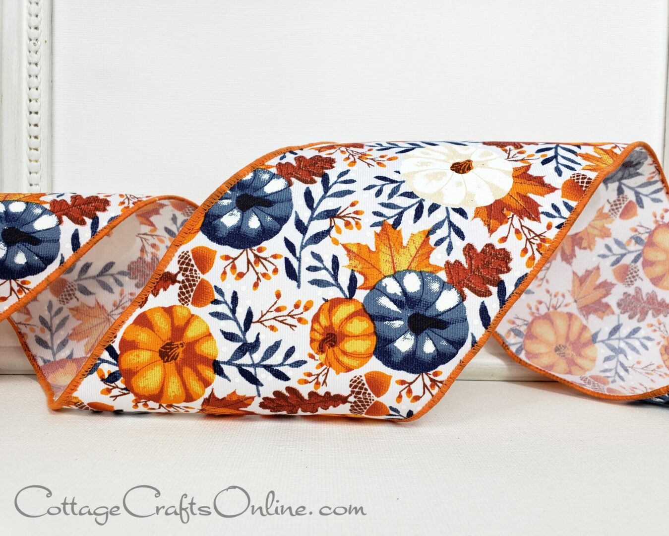 Navy orange white pumpkins and leaves on white 4" wide wired ribbon from the Etsy shop of Cottage Crafts Online.