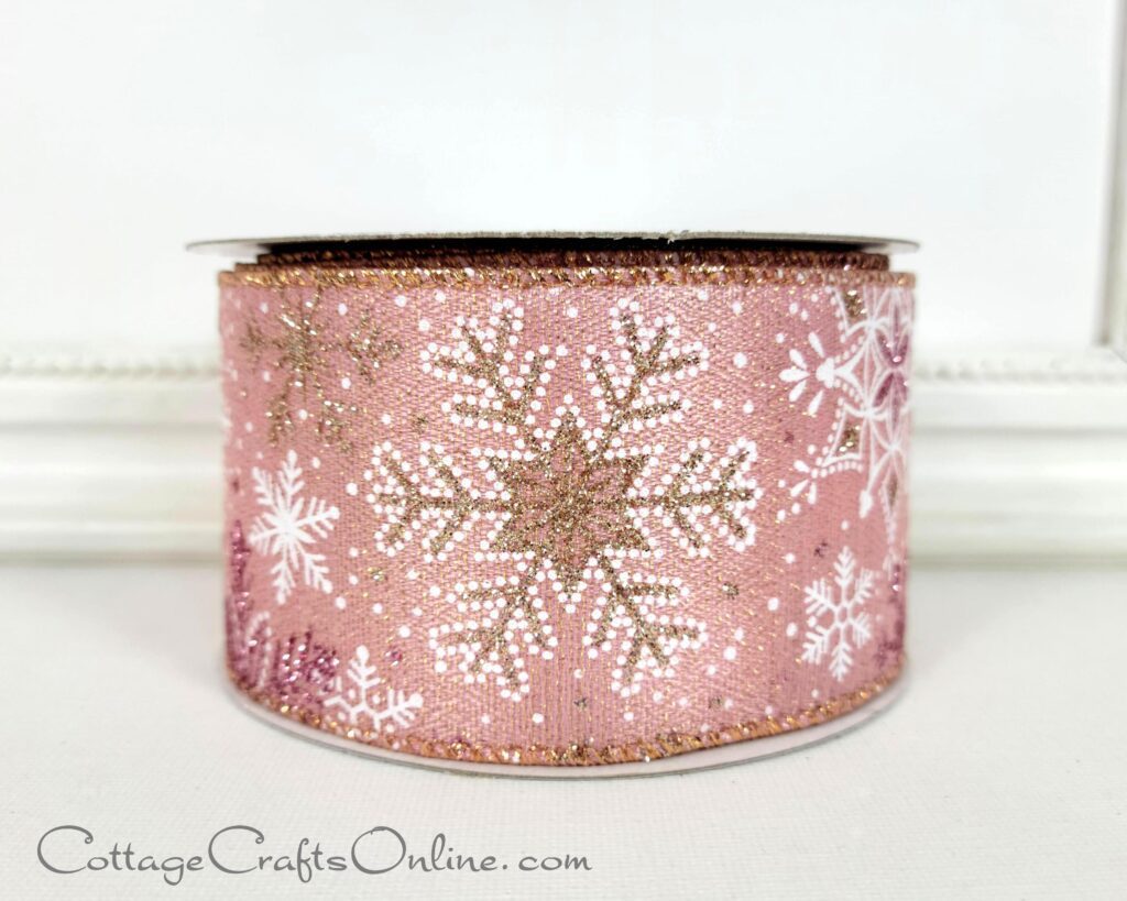 A pink ribbon with white and gold snowflakes.