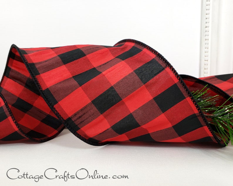 A red and black plaid ribbon is sitting on the table.