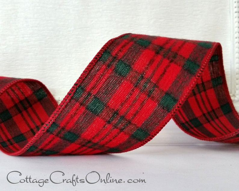 A red and black plaid ribbon is sitting on the table.
