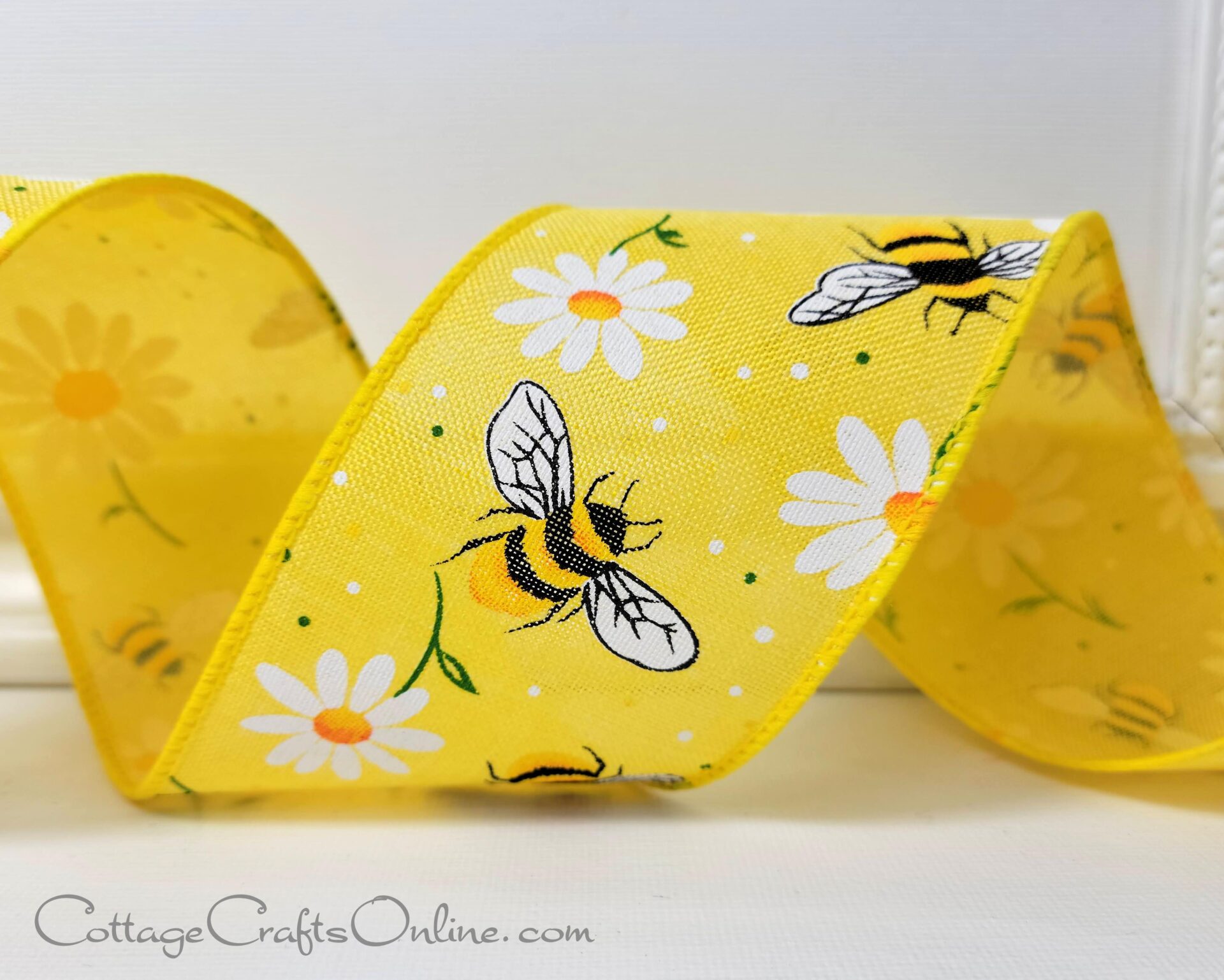 A yellow ribbon with bees and daisies on it.