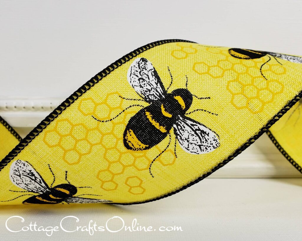 A yellow bee print purse sitting on top of a table.