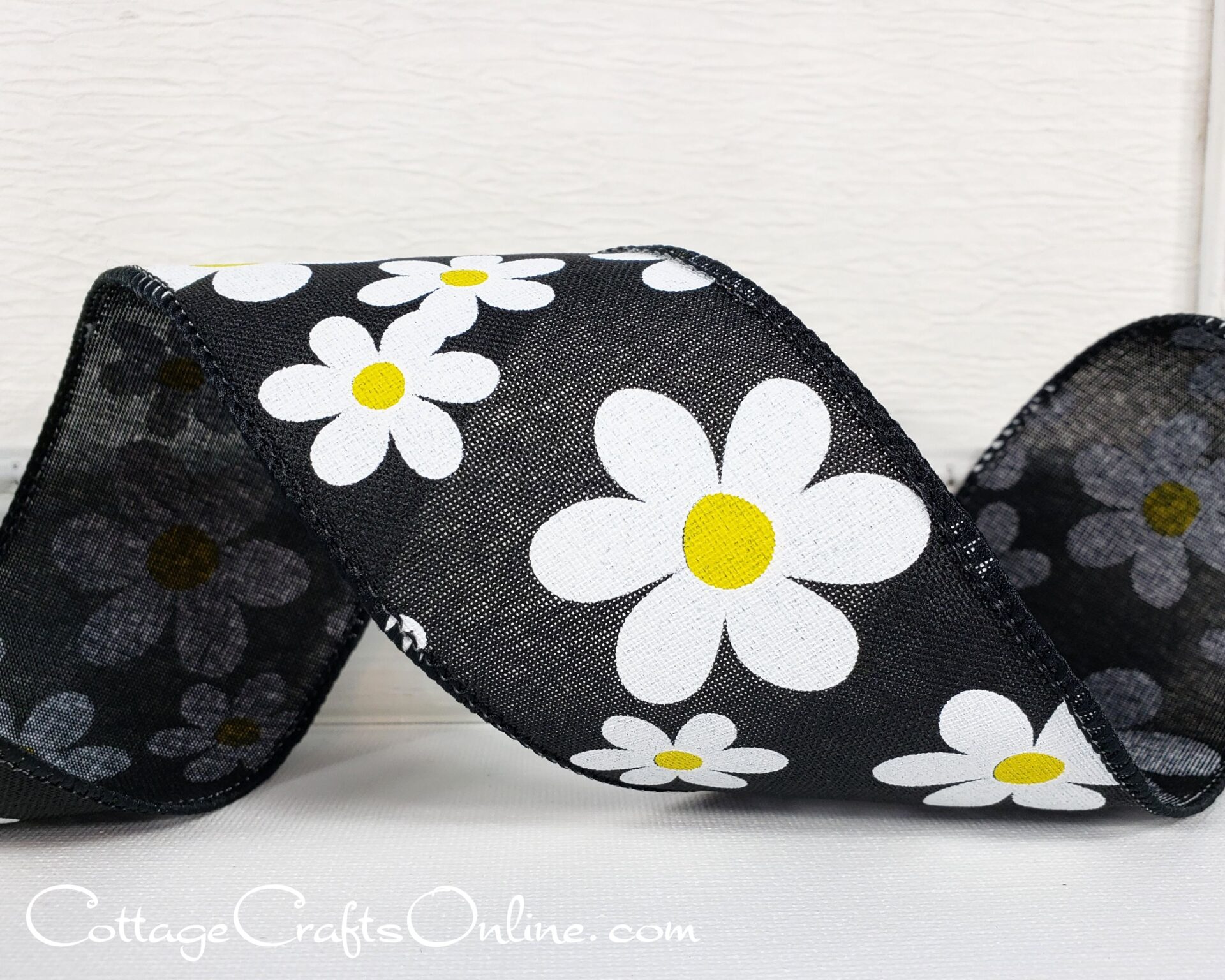 A black ribbon with white and yellow flowers.