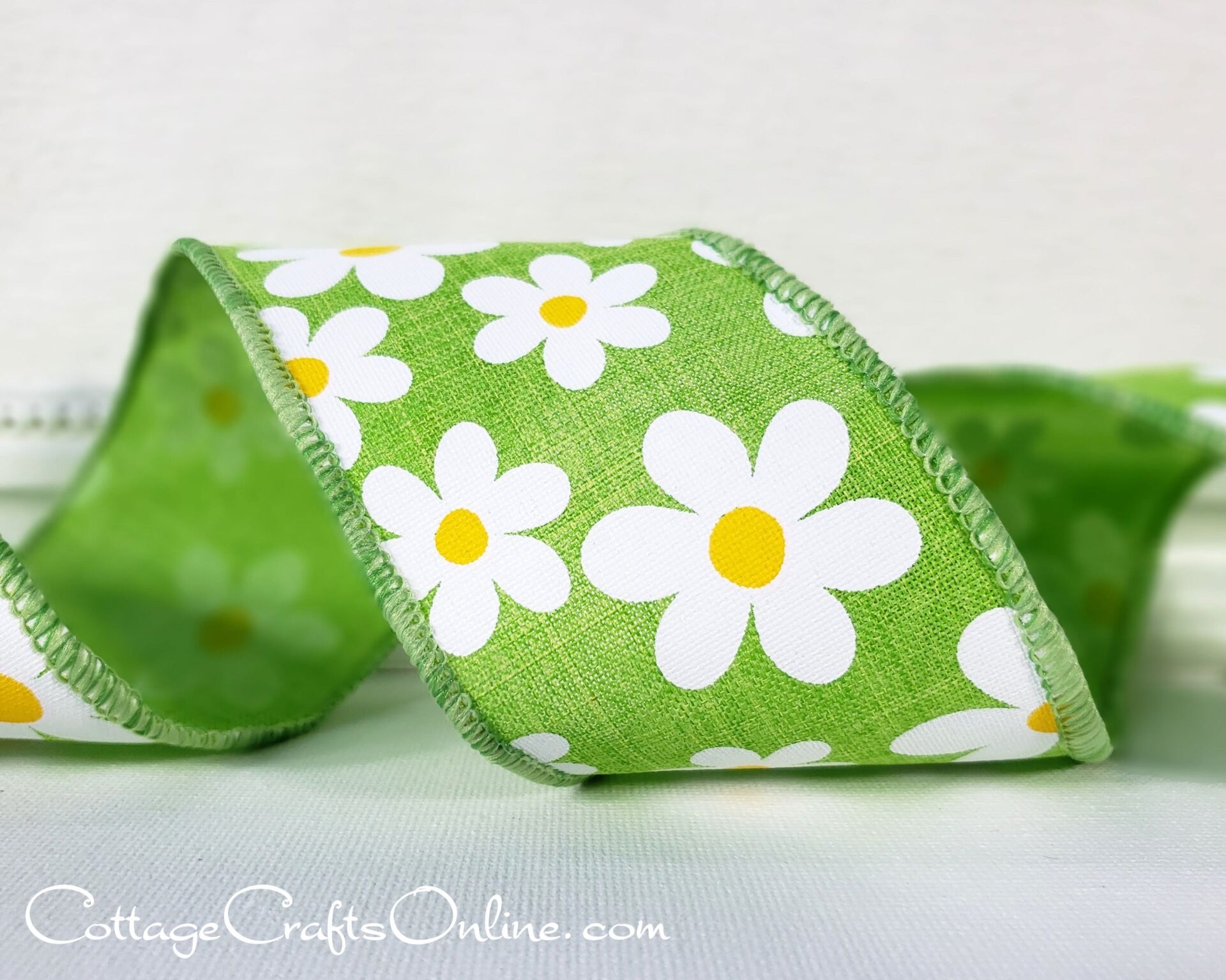 A green ribbon with white flowers on it.