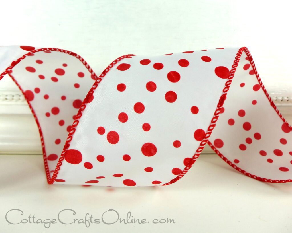 A red and white polka dot ribbon is sitting on top of a table.