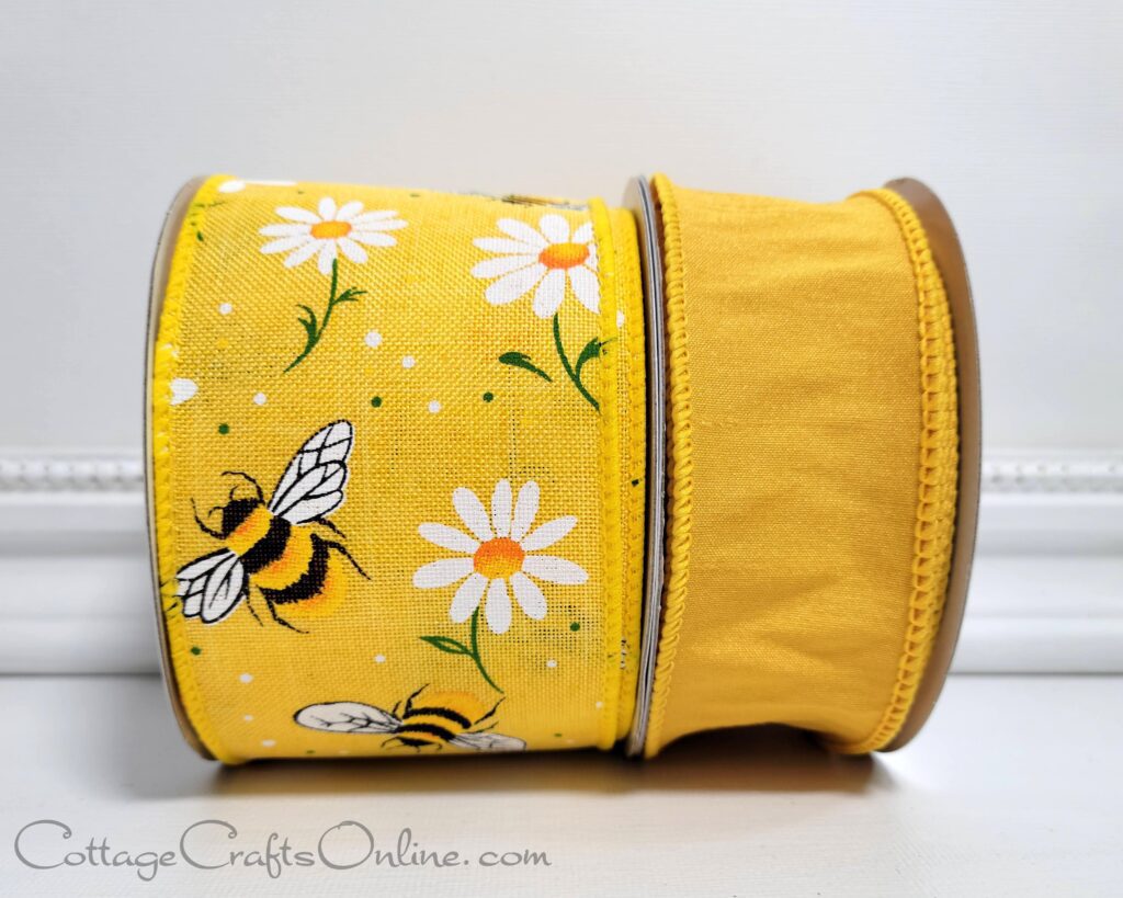 A yellow ribbon with bees and daisies on it.