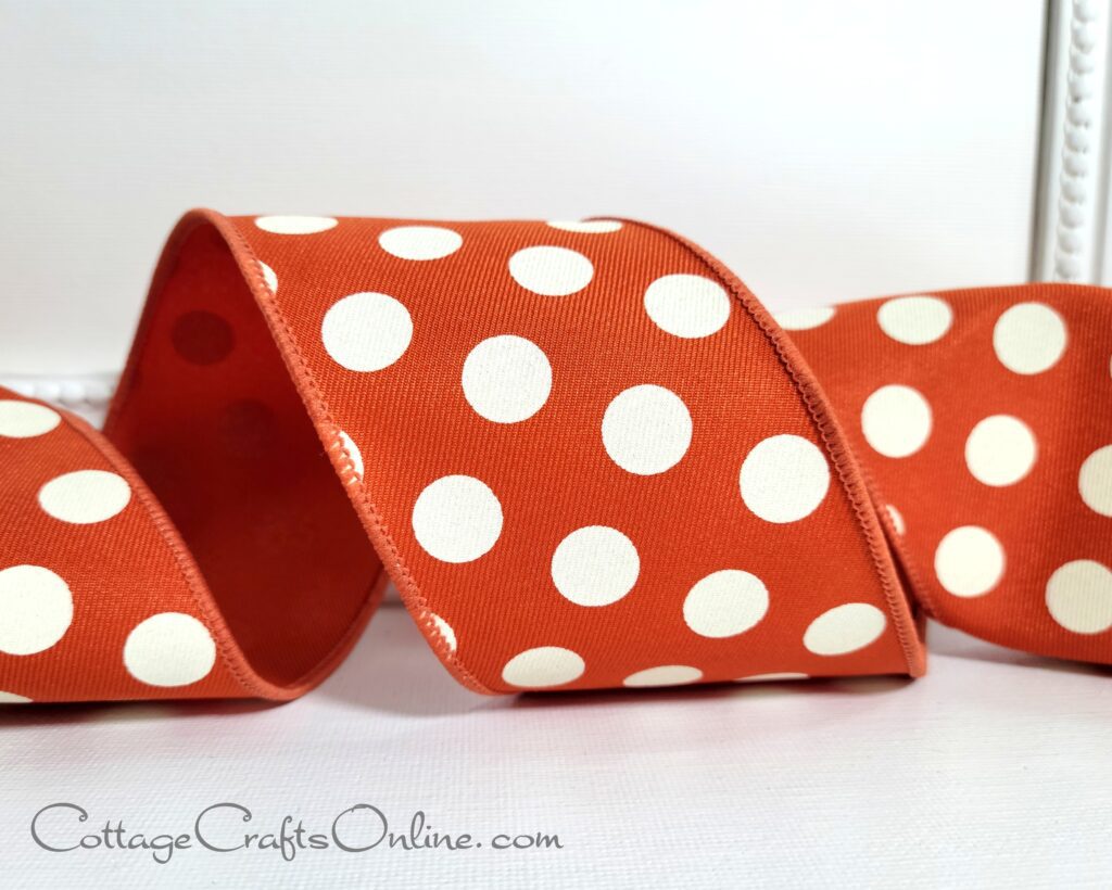 A red and white polka dot ribbon sitting on top of a table.