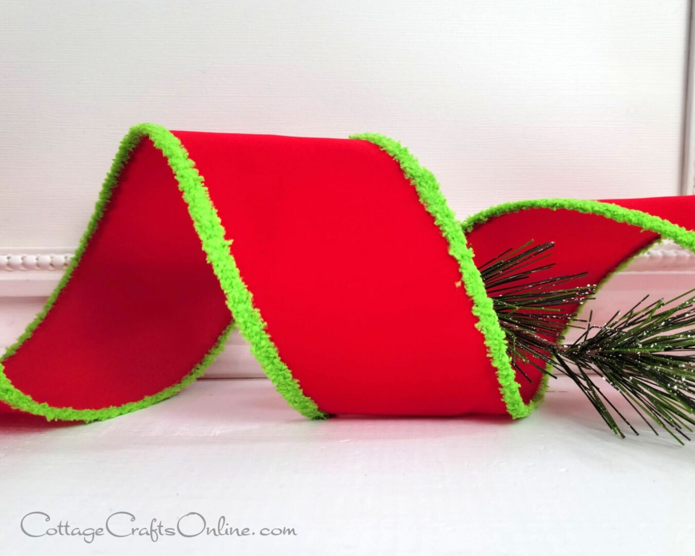 A red ribbon with green trim on top of it.
