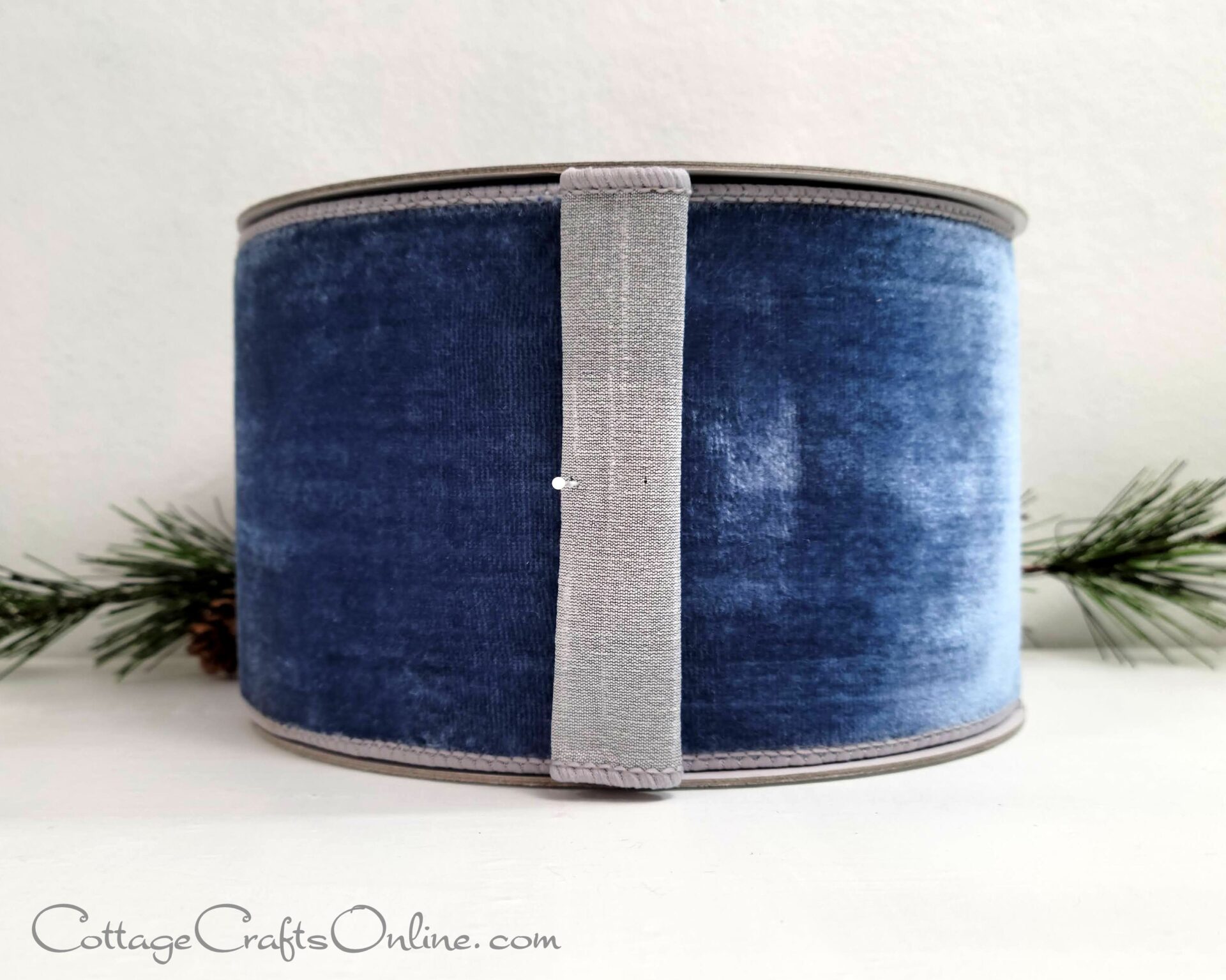 A blue velvet ribbon with silver trim on top of it.