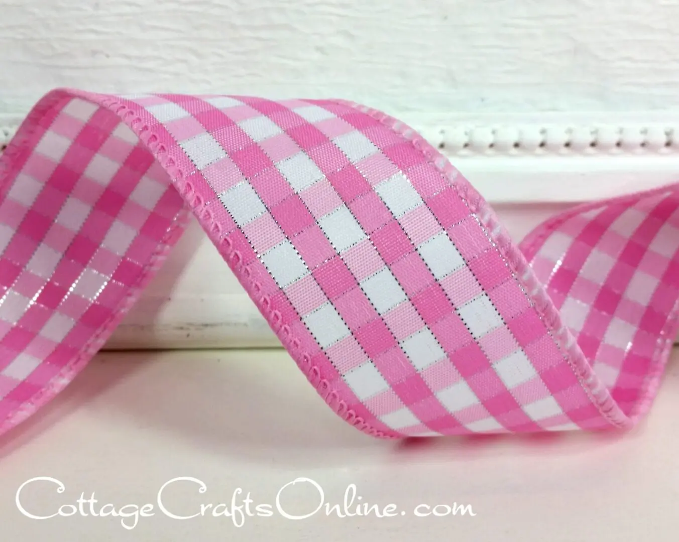 A pink and white checkered ribbon sitting on top of a table.