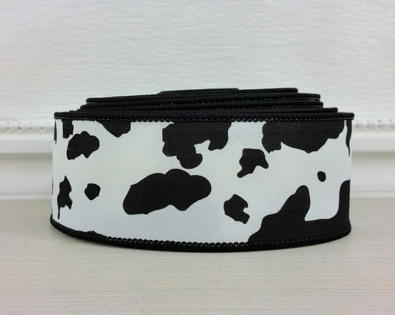 A black and white cow print ribbon is shown.