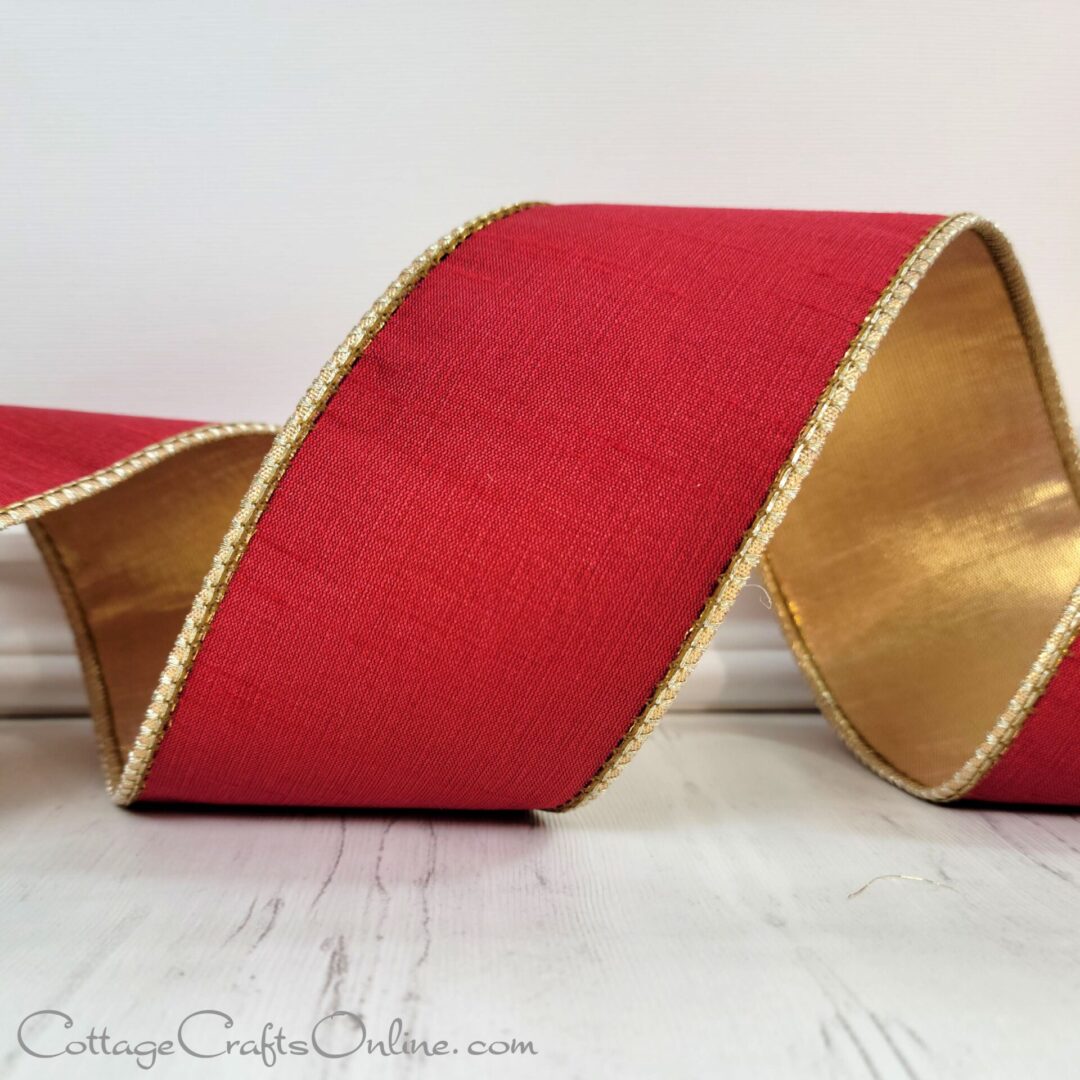 A red ribbon with gold trim on top of a table.