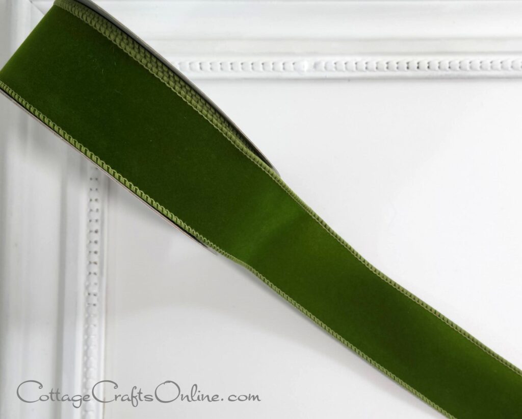A green ribbon is on the corner of a white picture frame.