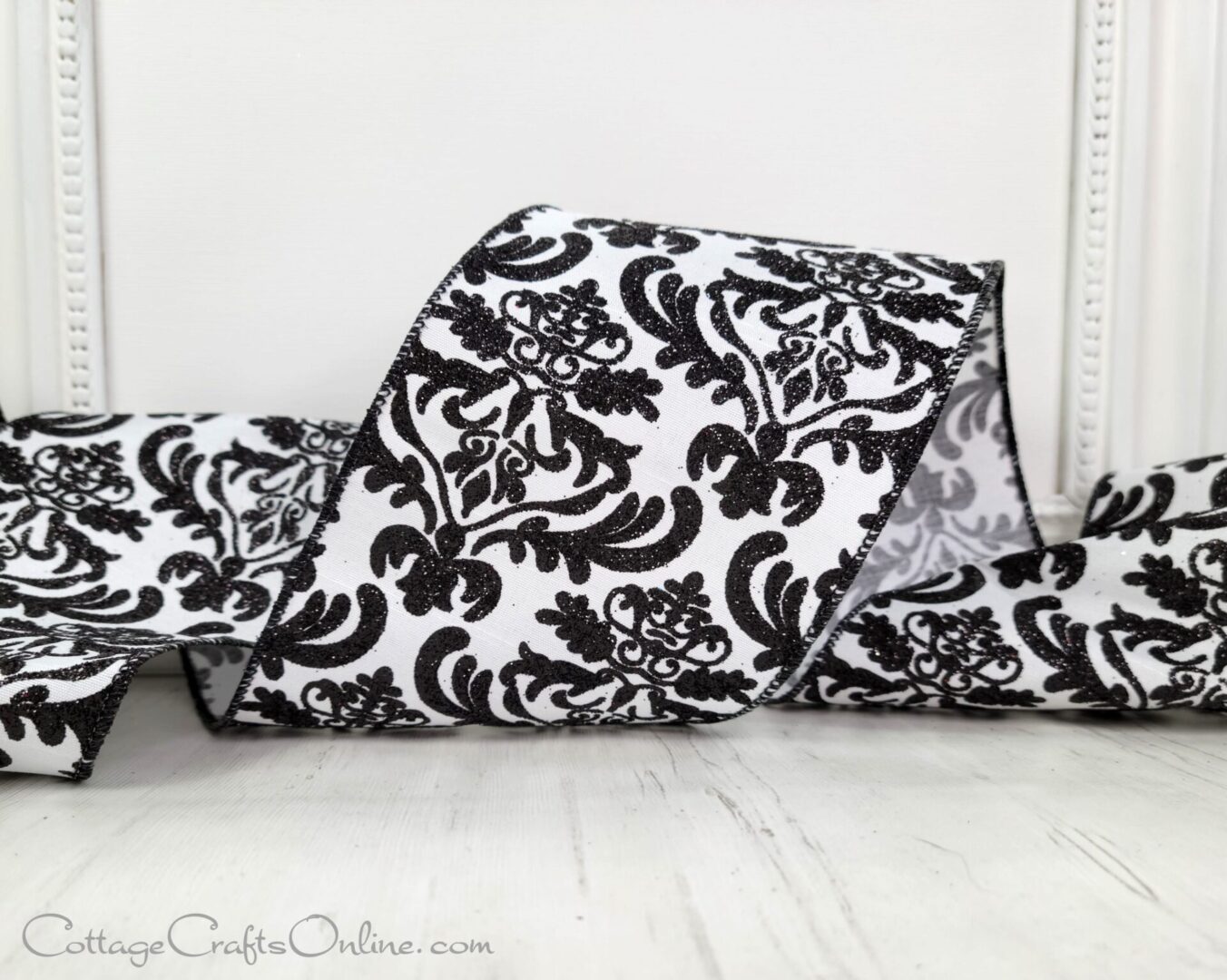 A black and white floral print blanket sitting on the floor.