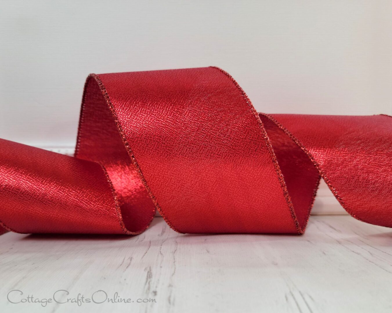 A red metallic ribbon is sitting on top of a table.