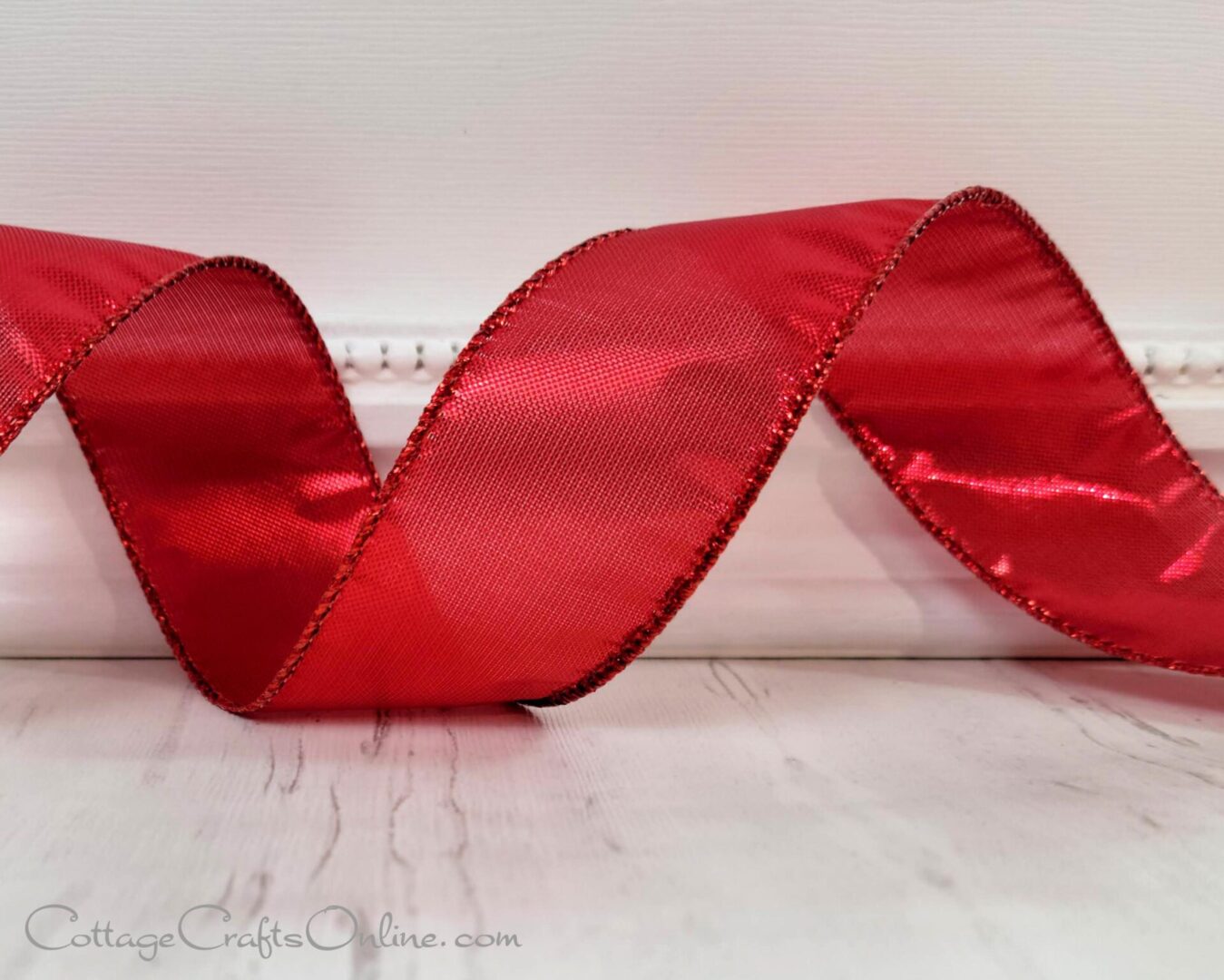 A red metallic ribbon is sitting on a table