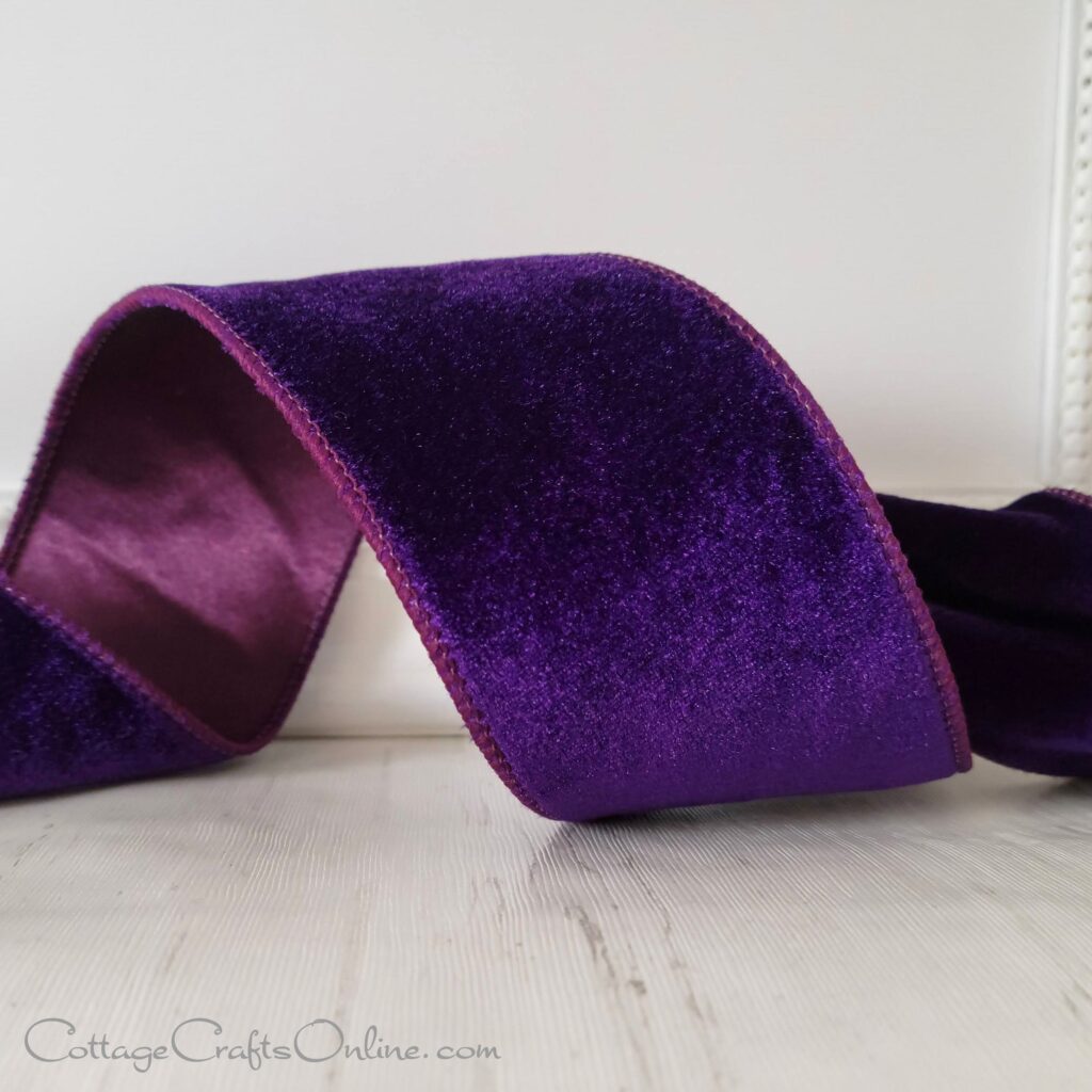 A purple velvet ribbon sitting on top of a table.