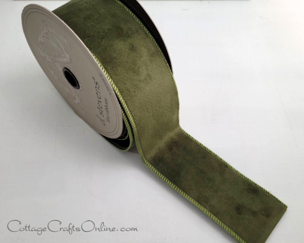 A roll of green velvet ribbon on top of a table.