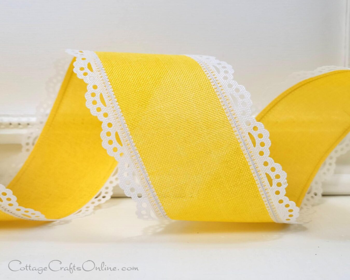 A yellow ribbon with white lace trim on it.