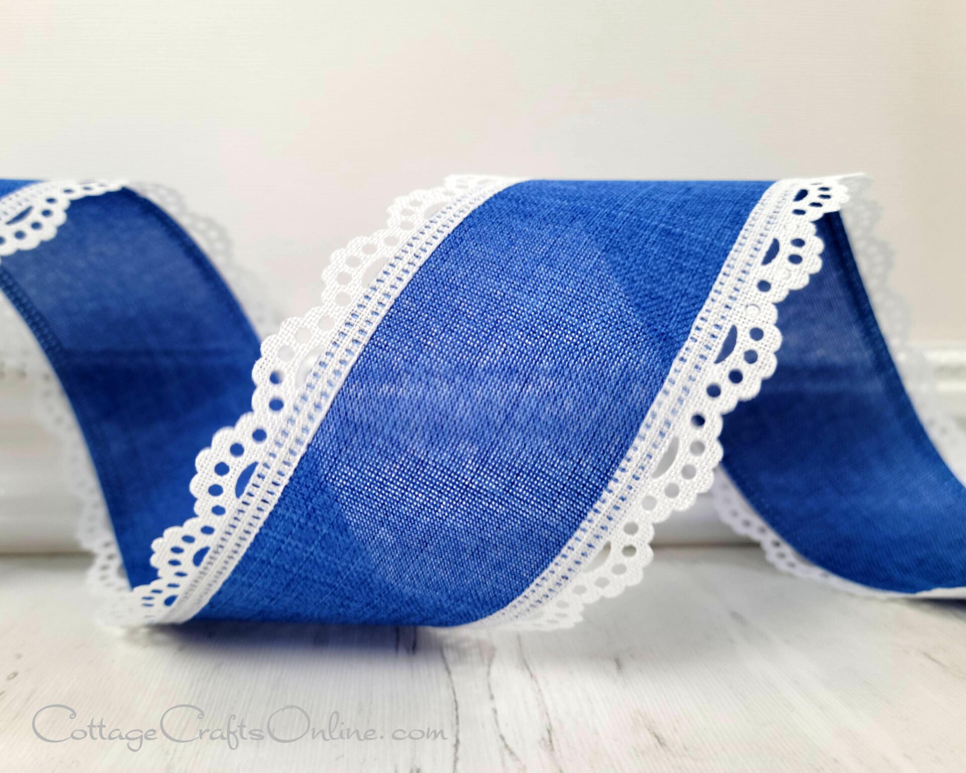 A blue ribbon with white lace trim on it.