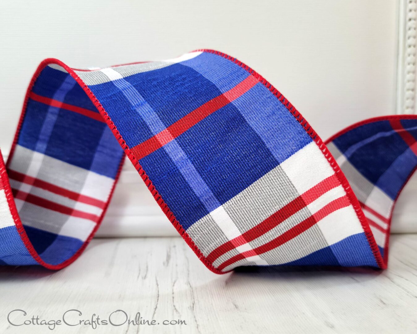 A close up of a re, white and blue plaid faux dupioni ribbon on a table