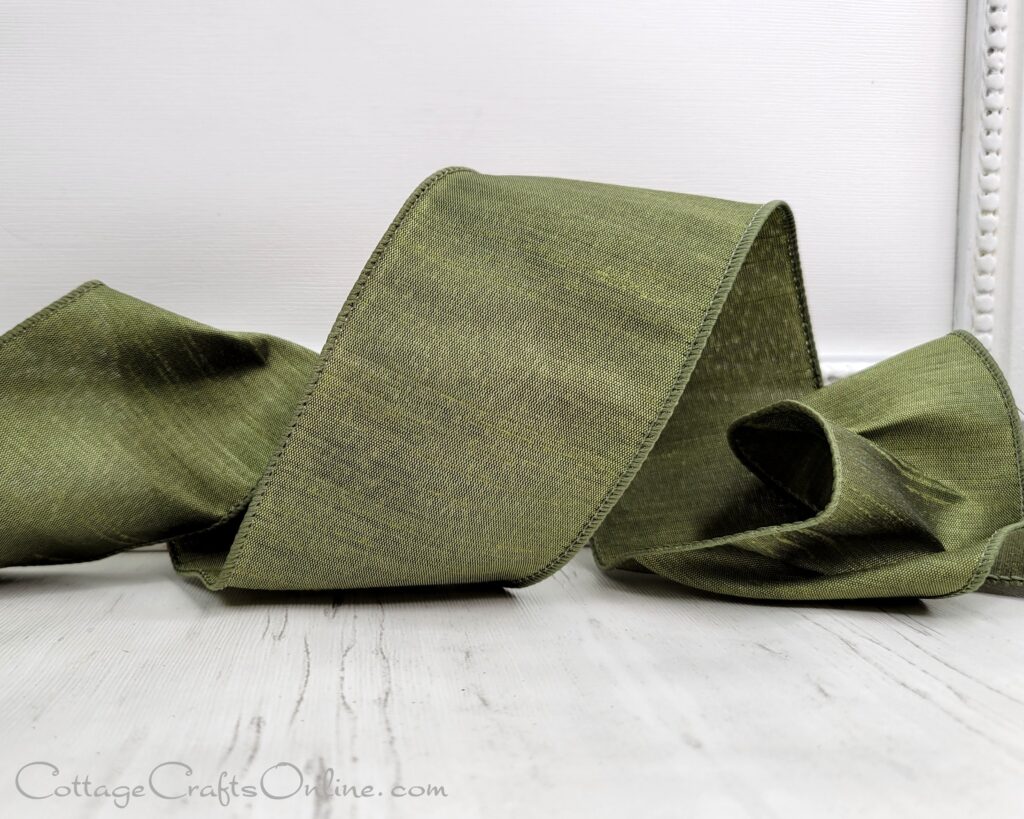 A green ribbon is laying on the floor