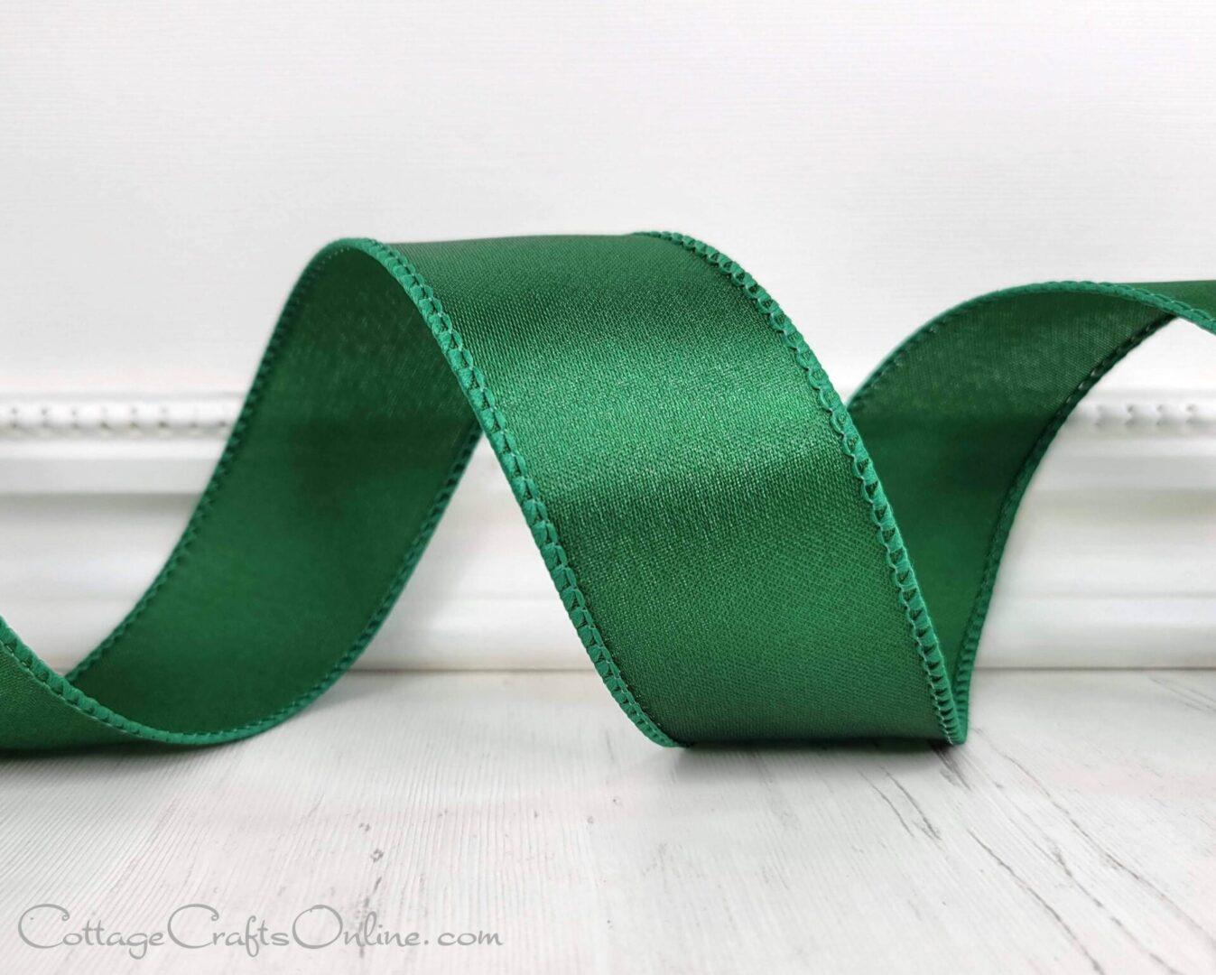 A green ribbon is sitting on the floor.
