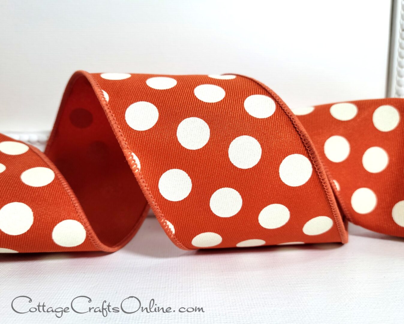 A red and white polka dot ribbon is sitting on the table.