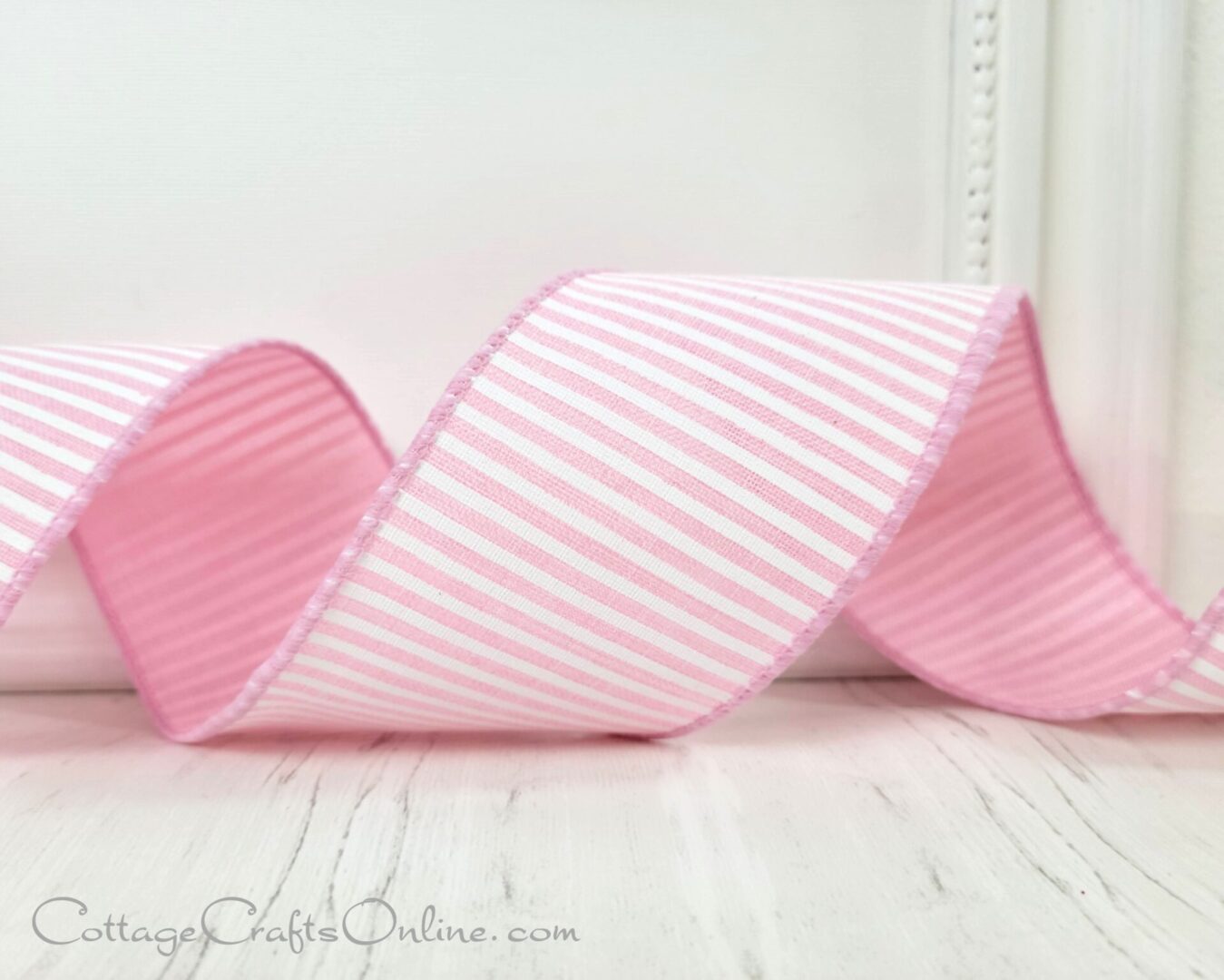 A pink and white striped ribbon sitting on top of a table.