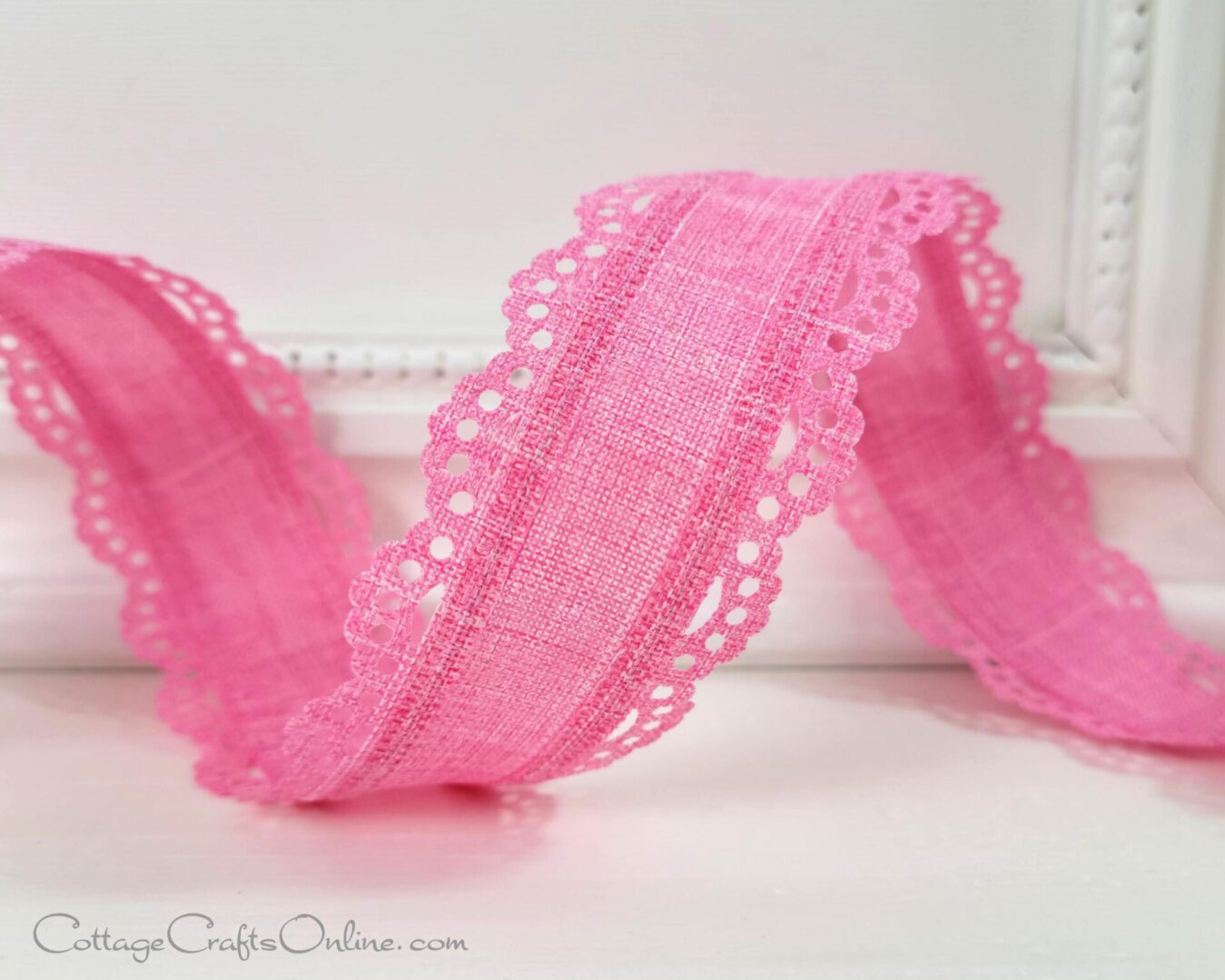 A pink ribbon with lace trim on it.