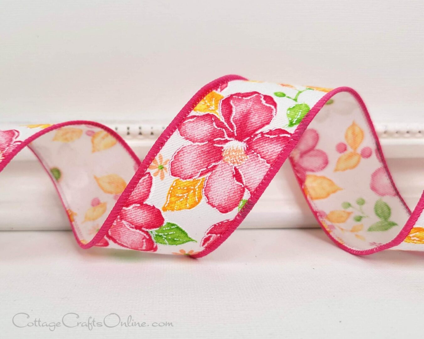 A pink and white floral ribbon sitting on top of a table.