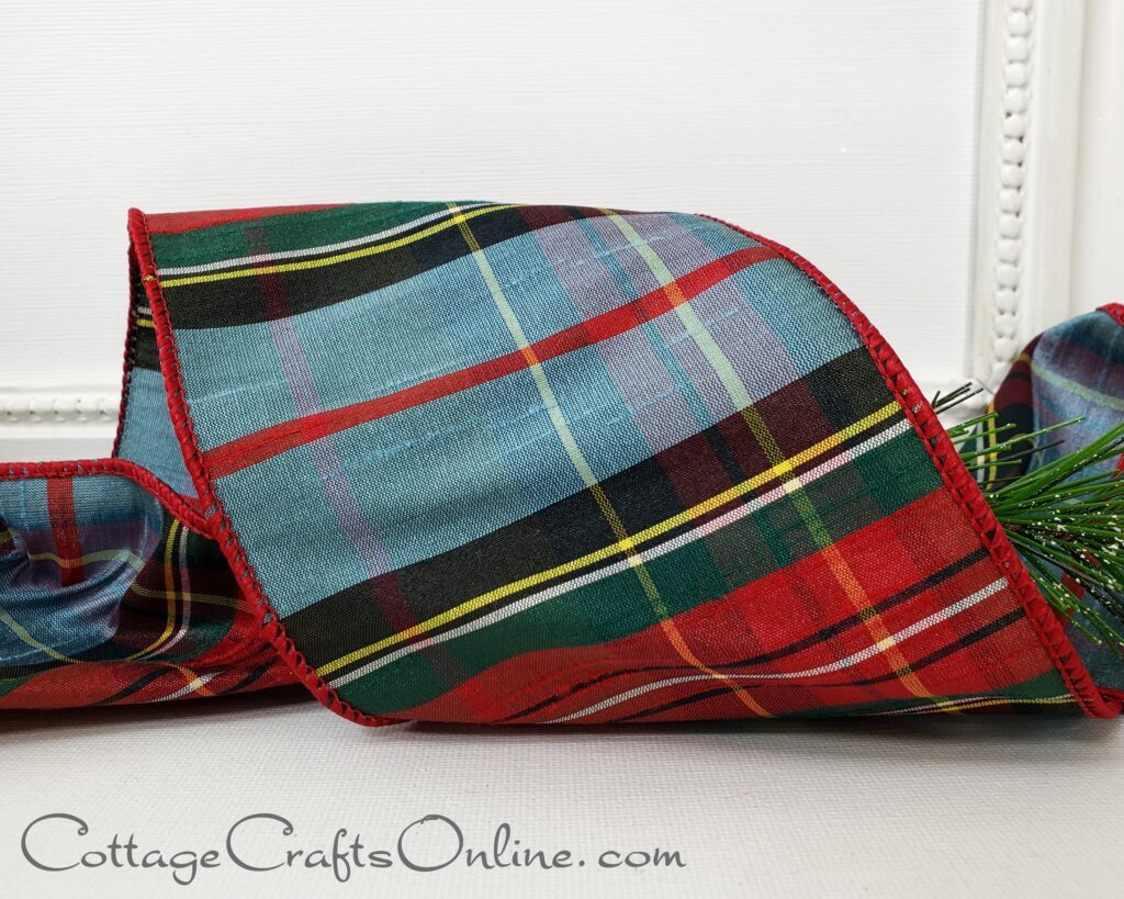 Dusty Blue Highland Plaid 4 inch wide wired faux dupioni ribbon by d stevens Fine Ribbons and sold by Cottage Crafts Online. The plaid is blue and red with green, black, yellow and white and a wired edge covered in red thread.