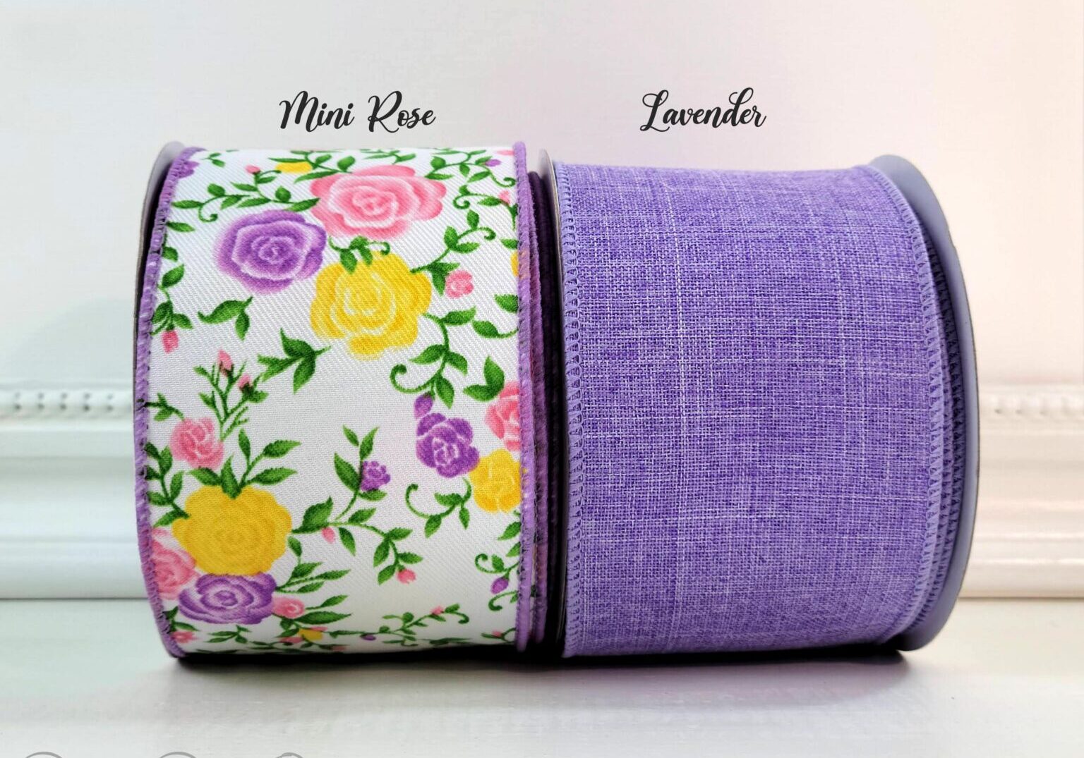 A purple ribbon with flowers on it and the same fabric as the ends of the ribbon.