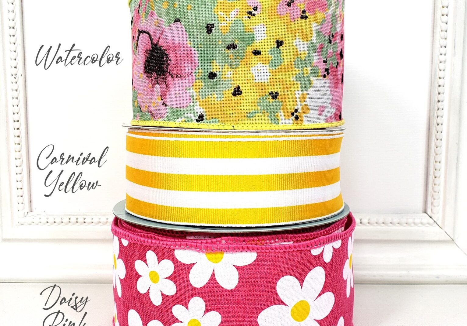 A stack of three different colored cake tins.